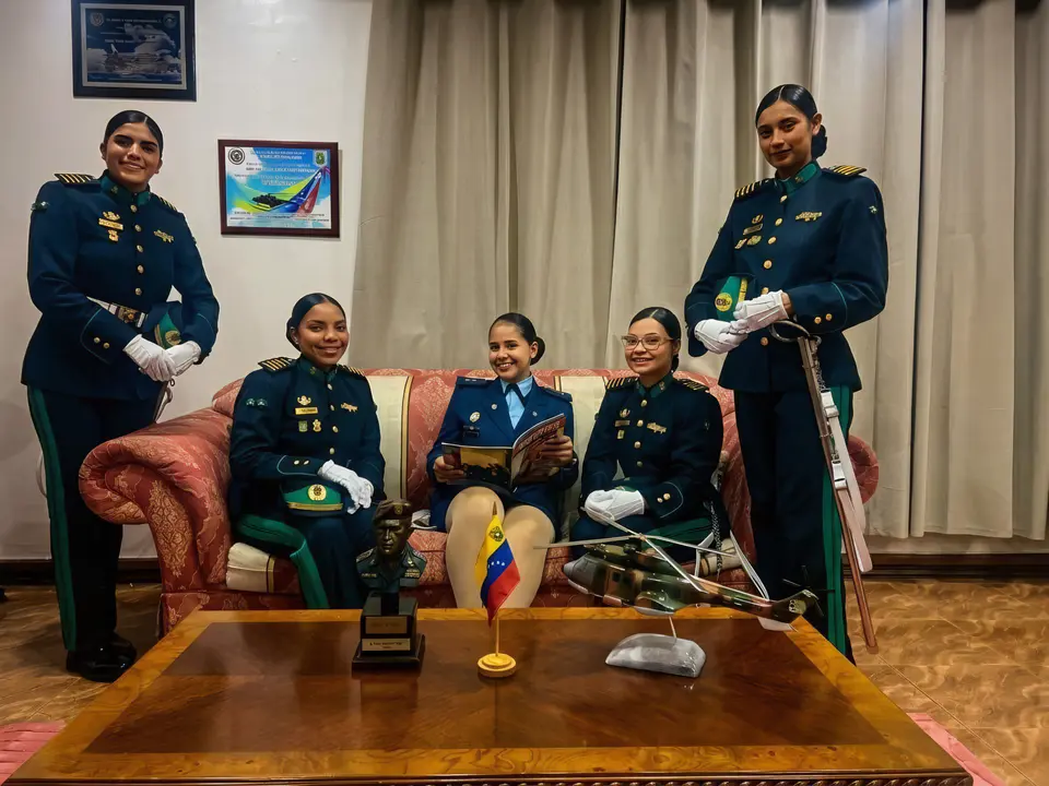 Cinco cadetes con uniforme de gala en un despacho de la academia